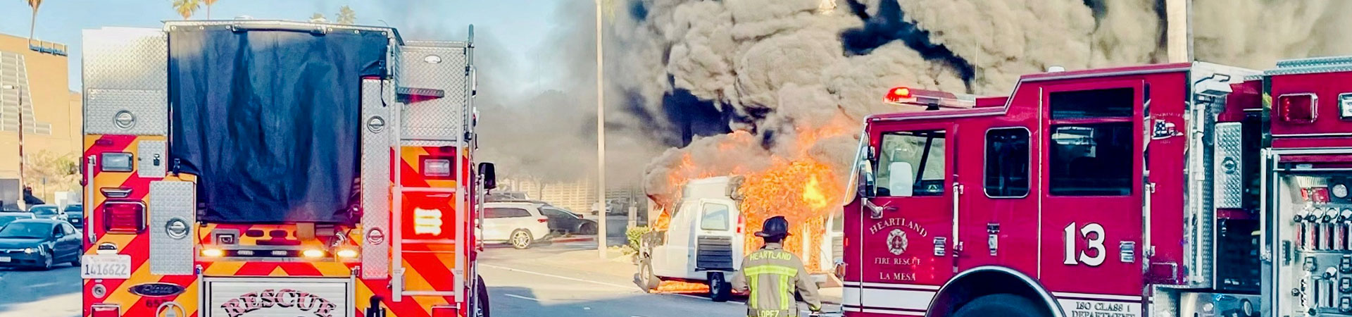 two firetrucks drive before billowing brown smoke